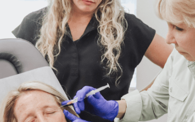 A woman is getting a botox injection in her forehead.