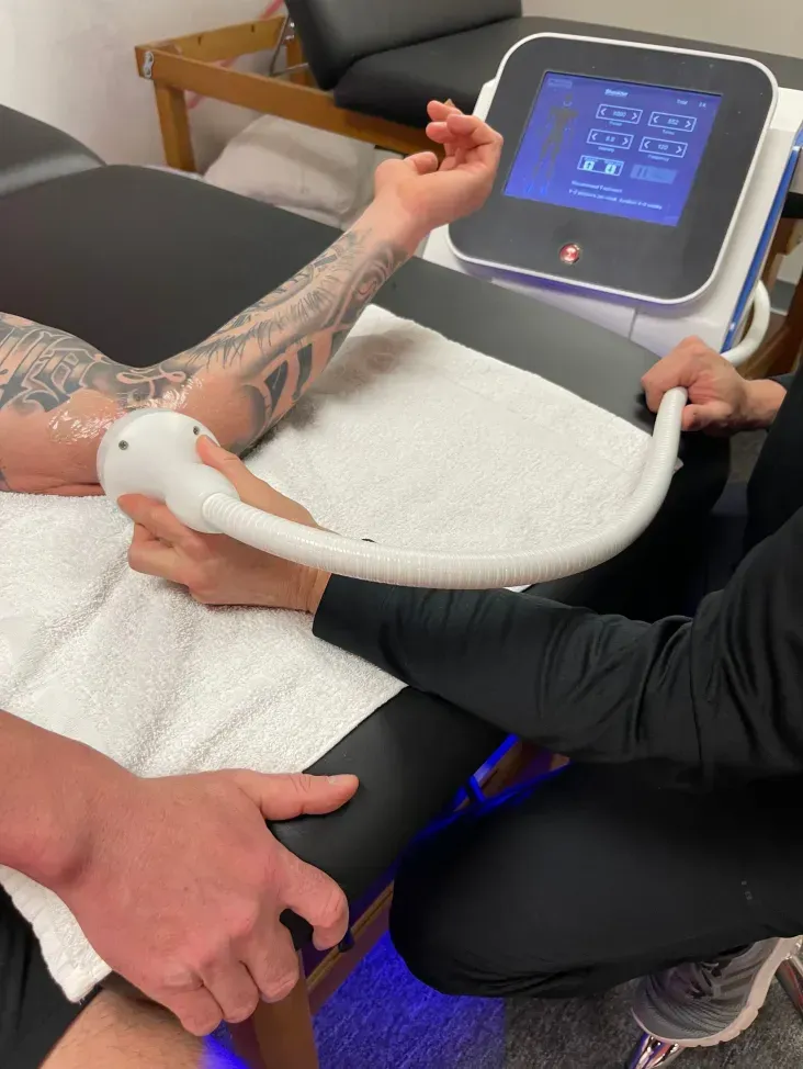 A person is getting a treatment on their wrist with a machine.