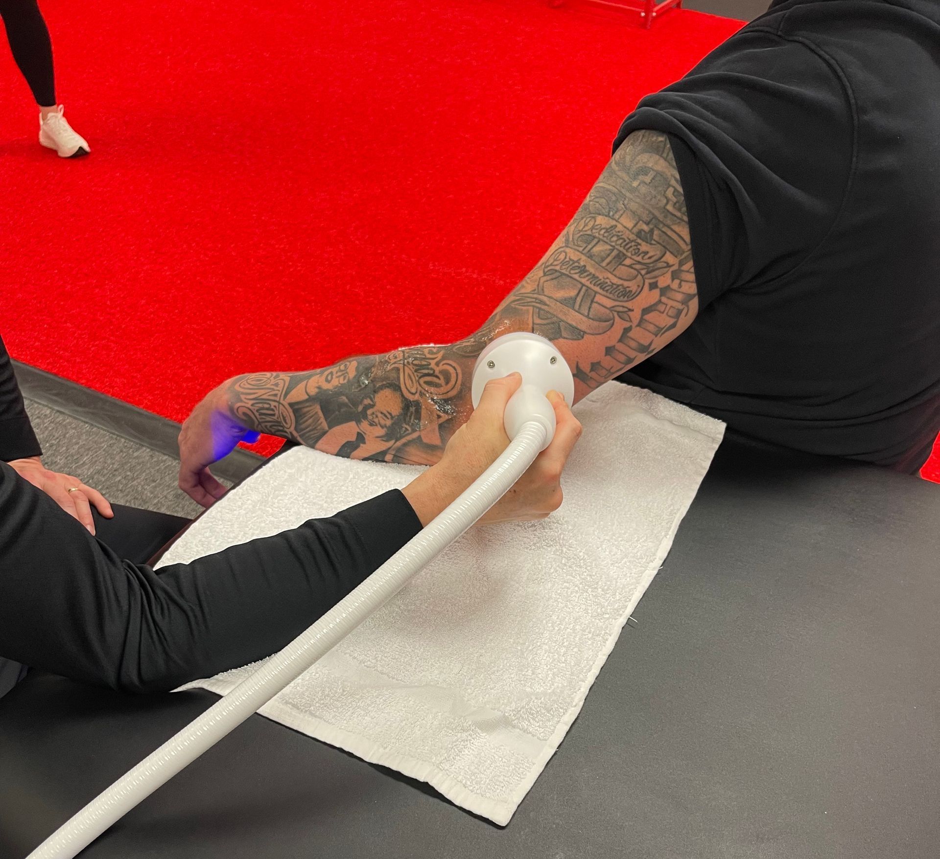 A man with tattoos is getting an ultrasound on his arm