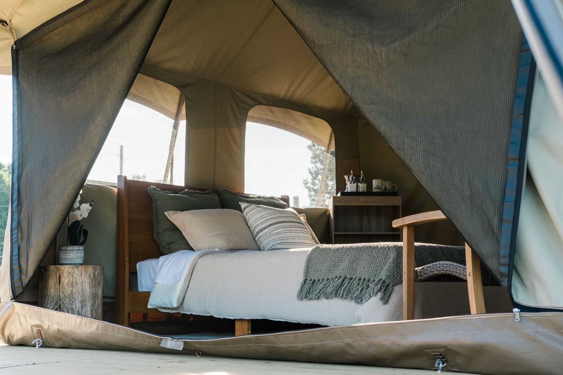 A tent with a bed and chair inside of it.