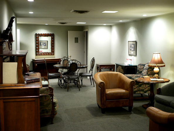 Cozy interior with seating areas, a round table, framed art, and warm lighting.