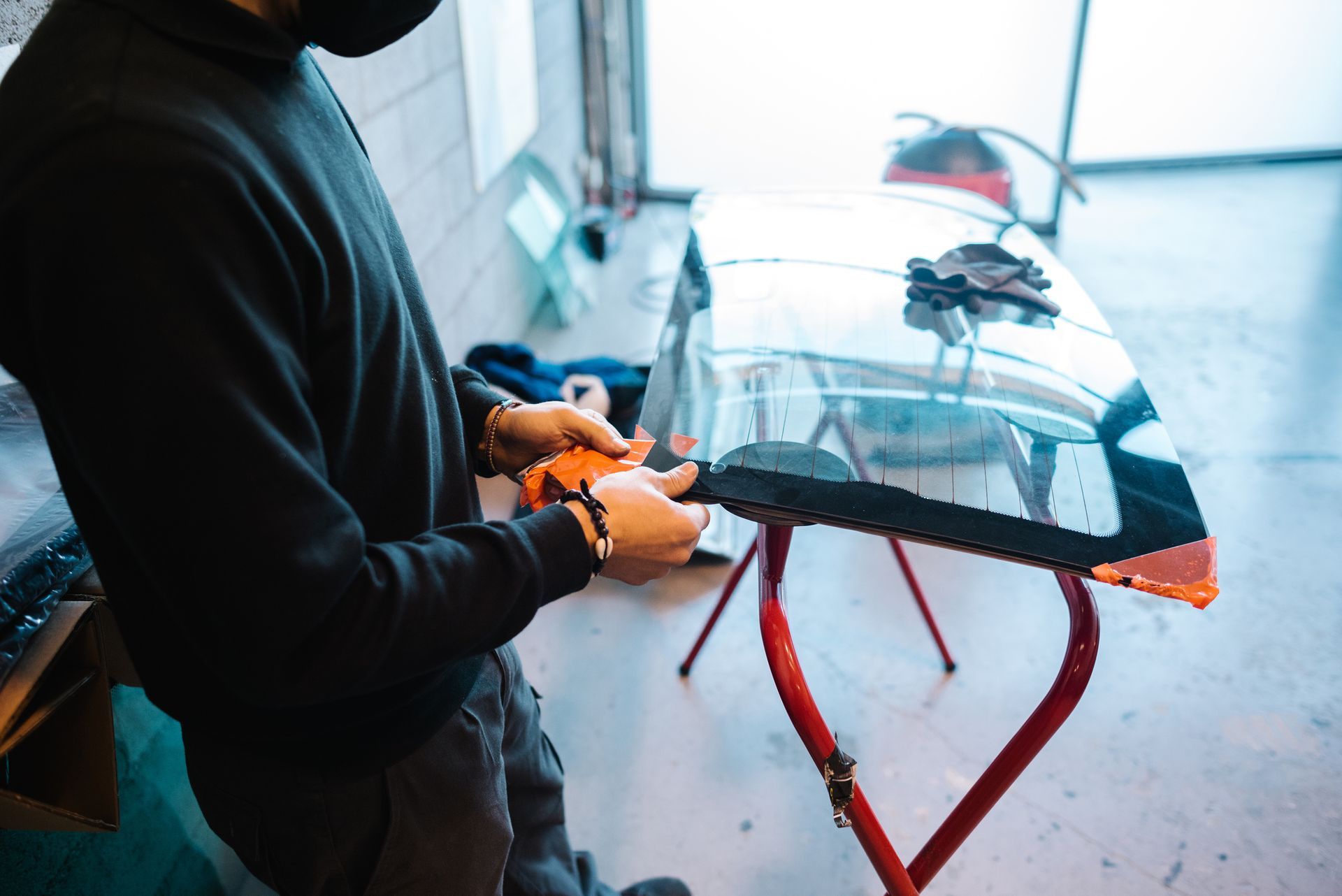 A man is working on a windshield in a garage - Drummond, MT - Big Sky Auto Glass and Screens