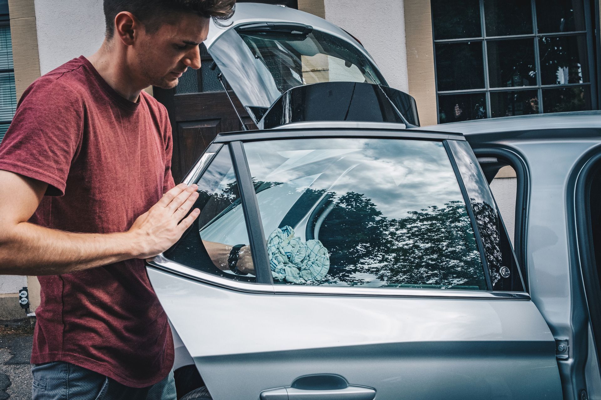 A man is standing next to a car with the door open - Drummond, MT - Big Sky Auto Glass and Screens