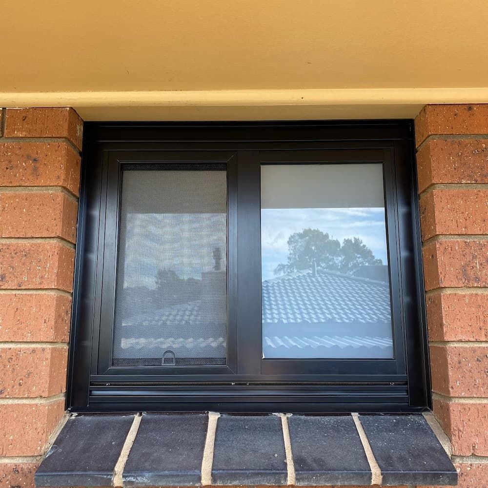 Black-framed Window With a Screen and a Partly-lowered Blind — Ingrams Installations in Cootamundra, NSW