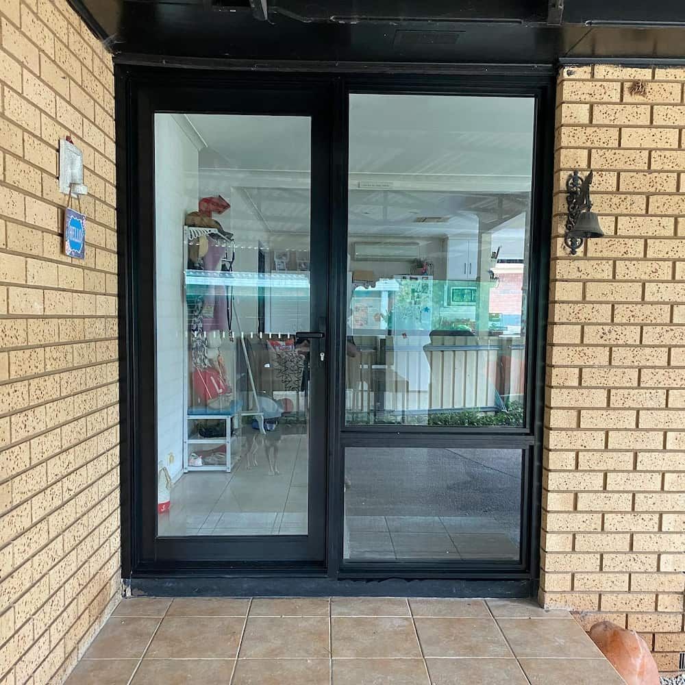 Black Framed Sliding Glass Door With a Window Below, Set in a Brick Wall — Ingrams Installations in Tumut, NSW