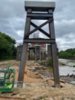 A large wooden tower is sitting next to a body of water.