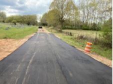 A car is driving down a newly paved road.