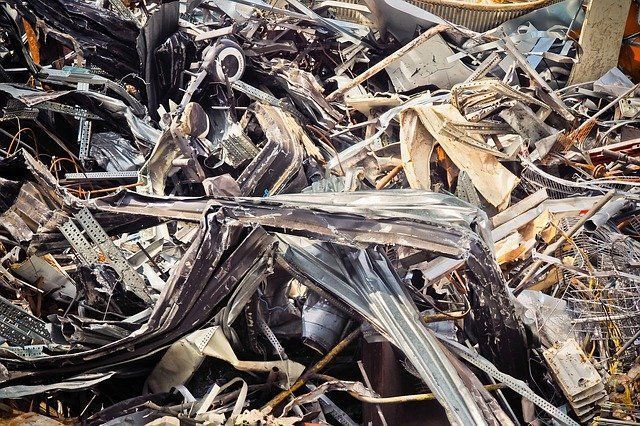 A pile of scrap metal is sitting on top of a pile of wood.