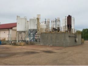 A factory with a lot of silos and a red roof