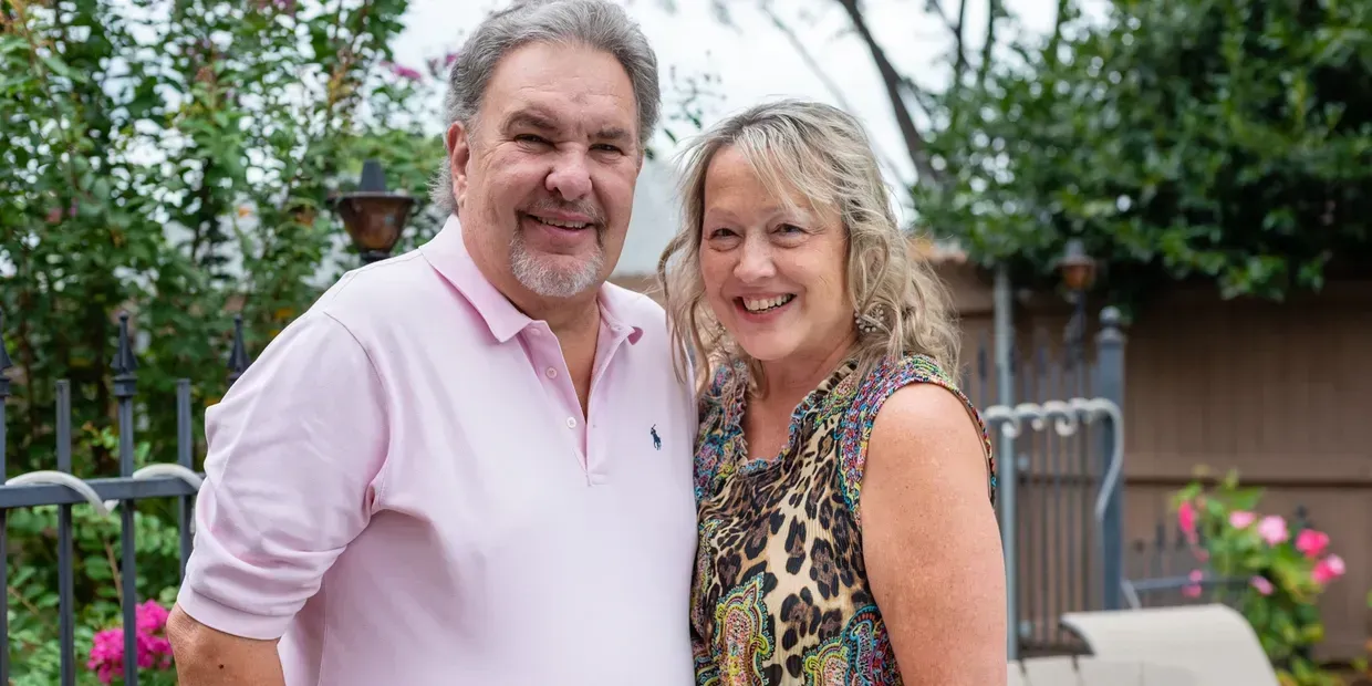 A man and a woman are standing next to each other and smiling for the camera.