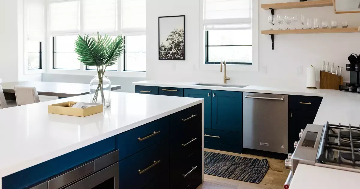 Bright kitchen with navy cabinets and gold accents reflecting stylish home remodeling trends