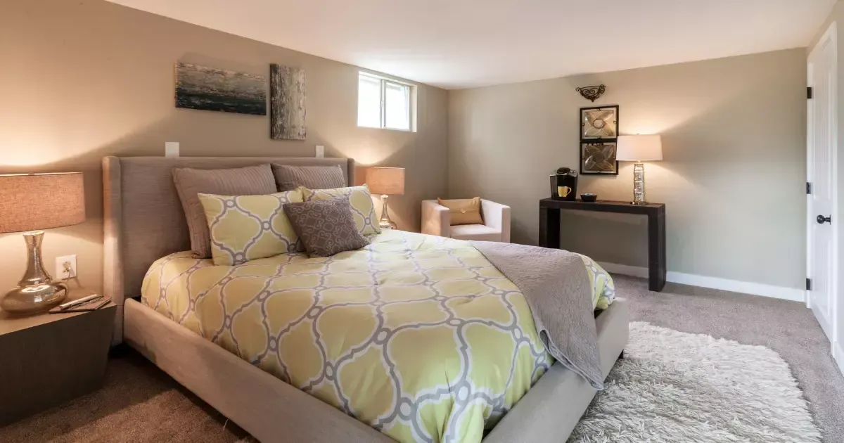 Cozy basement bedroom with carpet and warm lighting