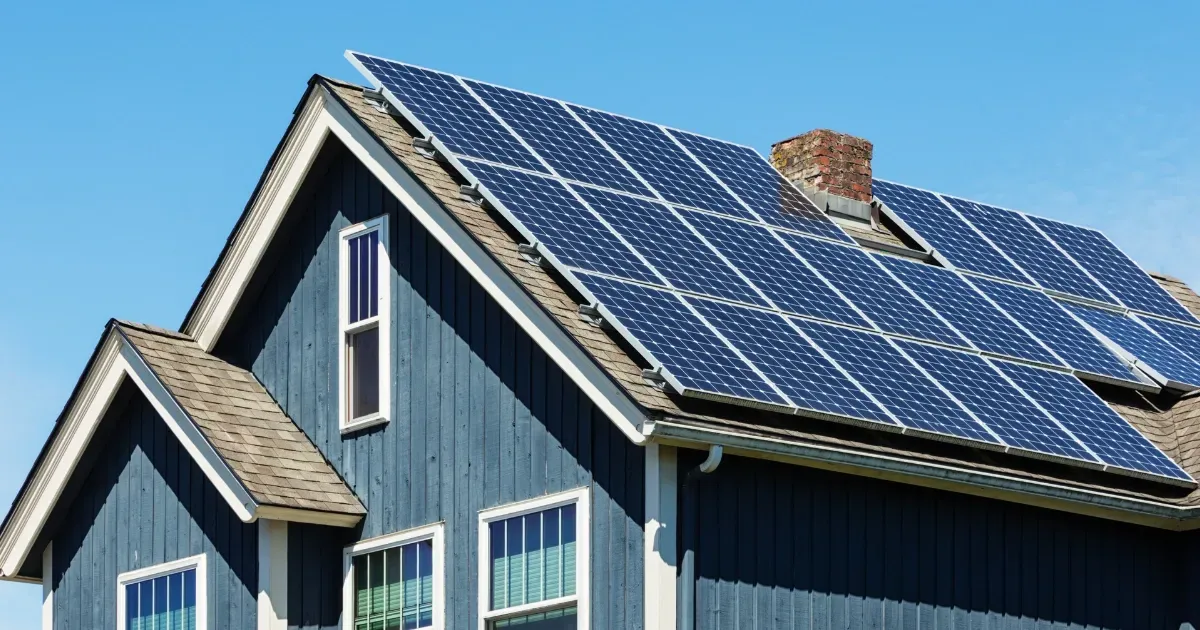 Blue house roof covered with solar panels generating clean renewable energy