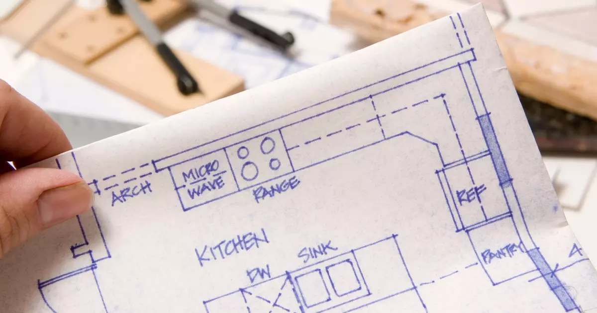 Kitchen layout blueprint held in hand at a construction site