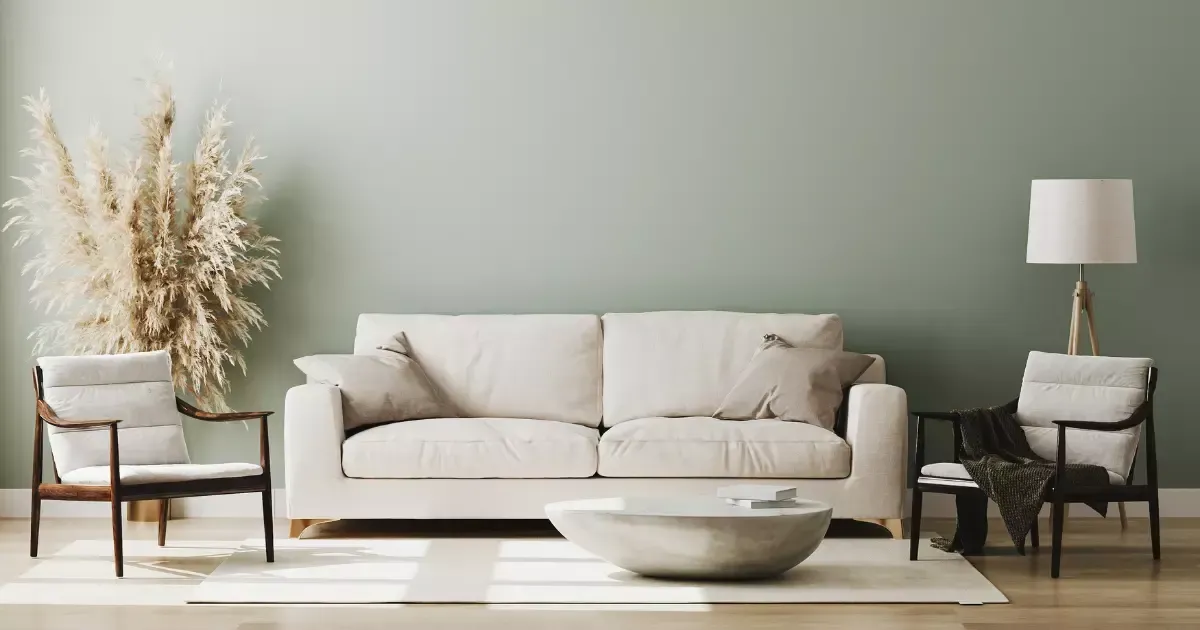 Modern neutral-toned space with a beige sofa, wooden chairs, pampas grass, and a round coffee table, showcasing cozy living room design ideas