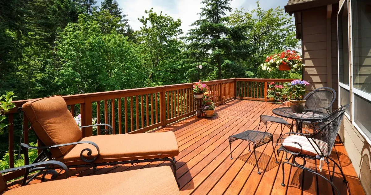 Outdoor deck with furniture and floral accents highlighting warm deck handrail ideas