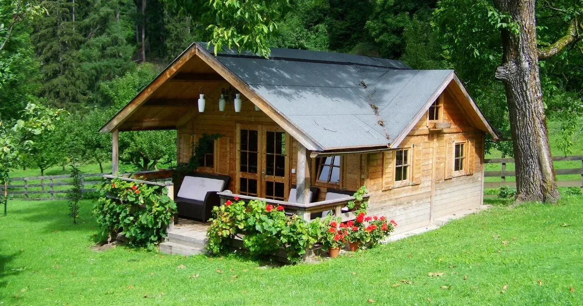 Small wooden cottage in a garden setting built through guest house construction