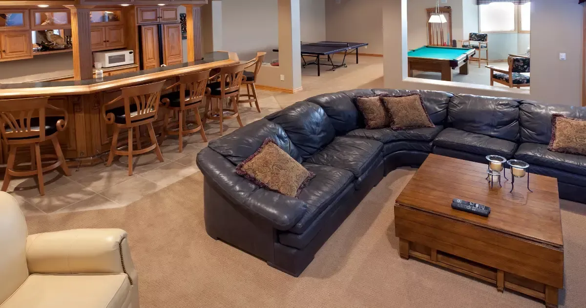 Spacious basement game room with bar, seating, and games