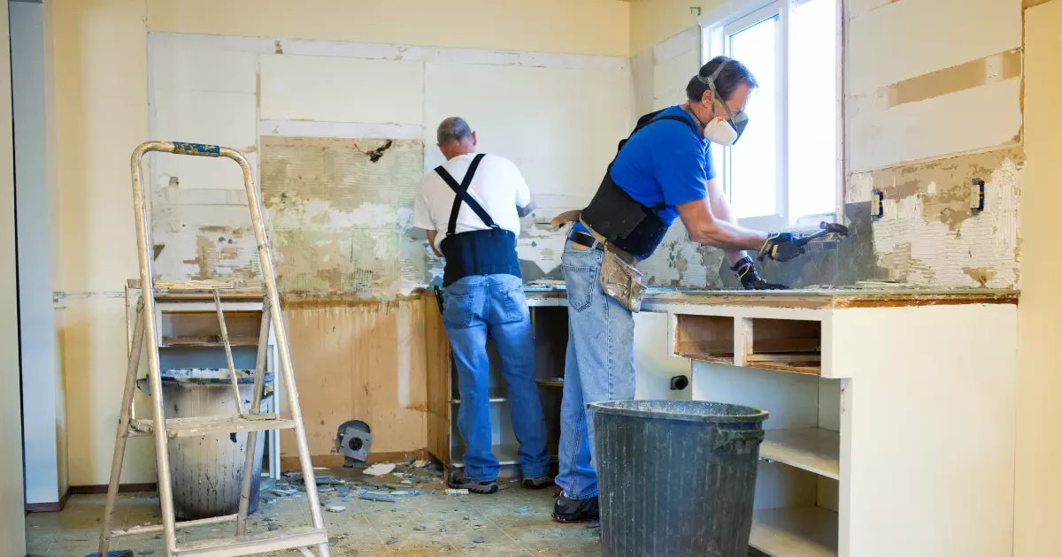 Workers tearing down outdated kitchen cabinets