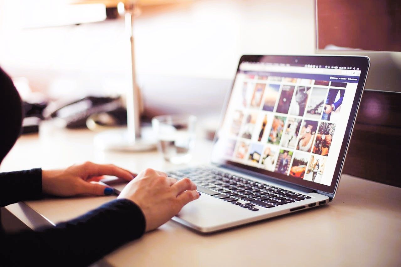 Person doing digital marketing on laptop with image grid on screen