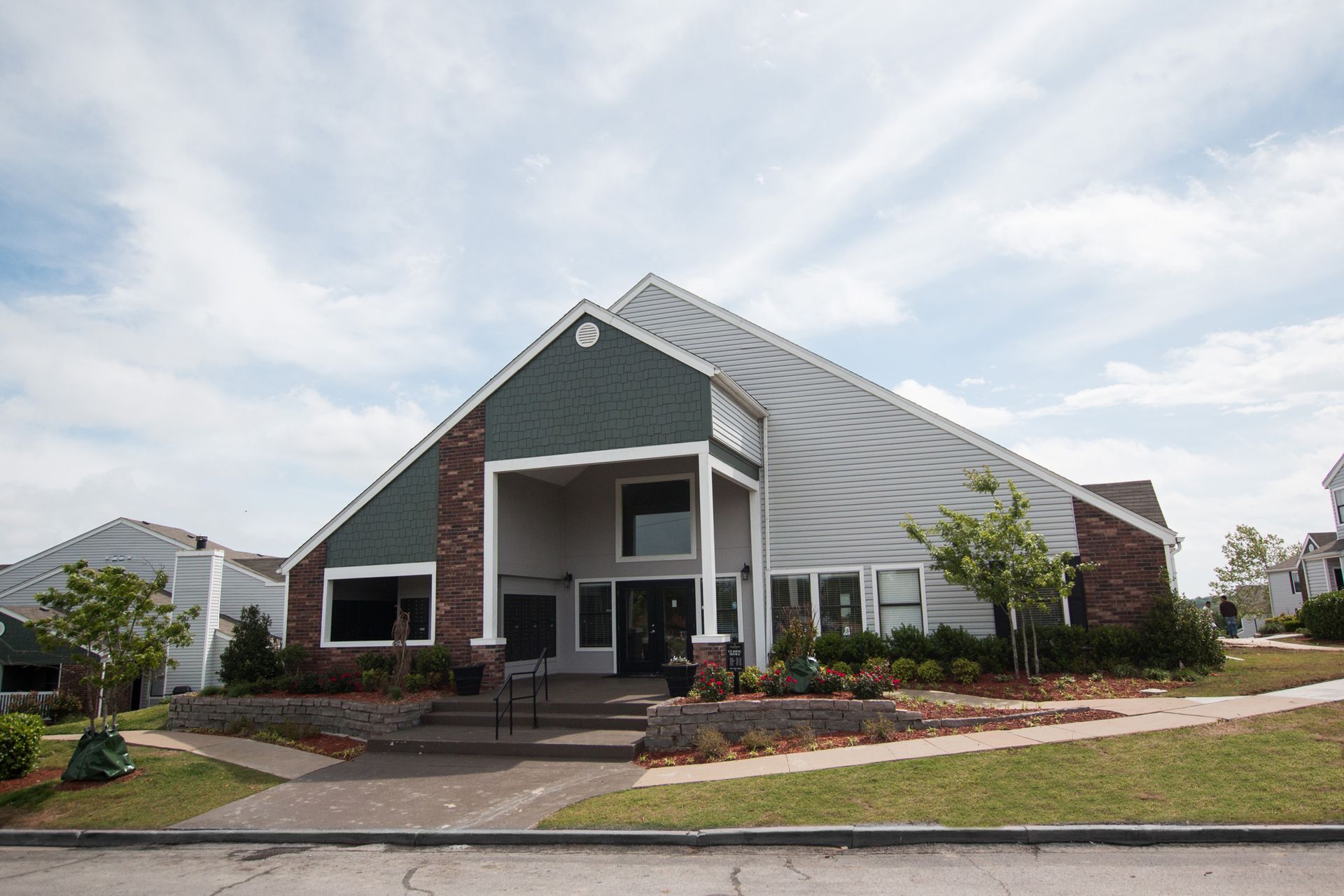 A large white house with a green roof and a porch