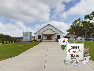 A white barn with a sign that says steel magnolia barn