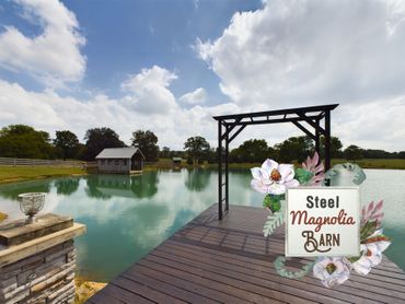 A dock overlooking a lake with a sign that says steel magnolia barn