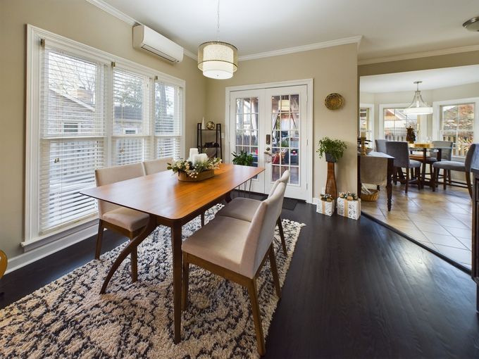 A dining room with a table and chairs and a rug