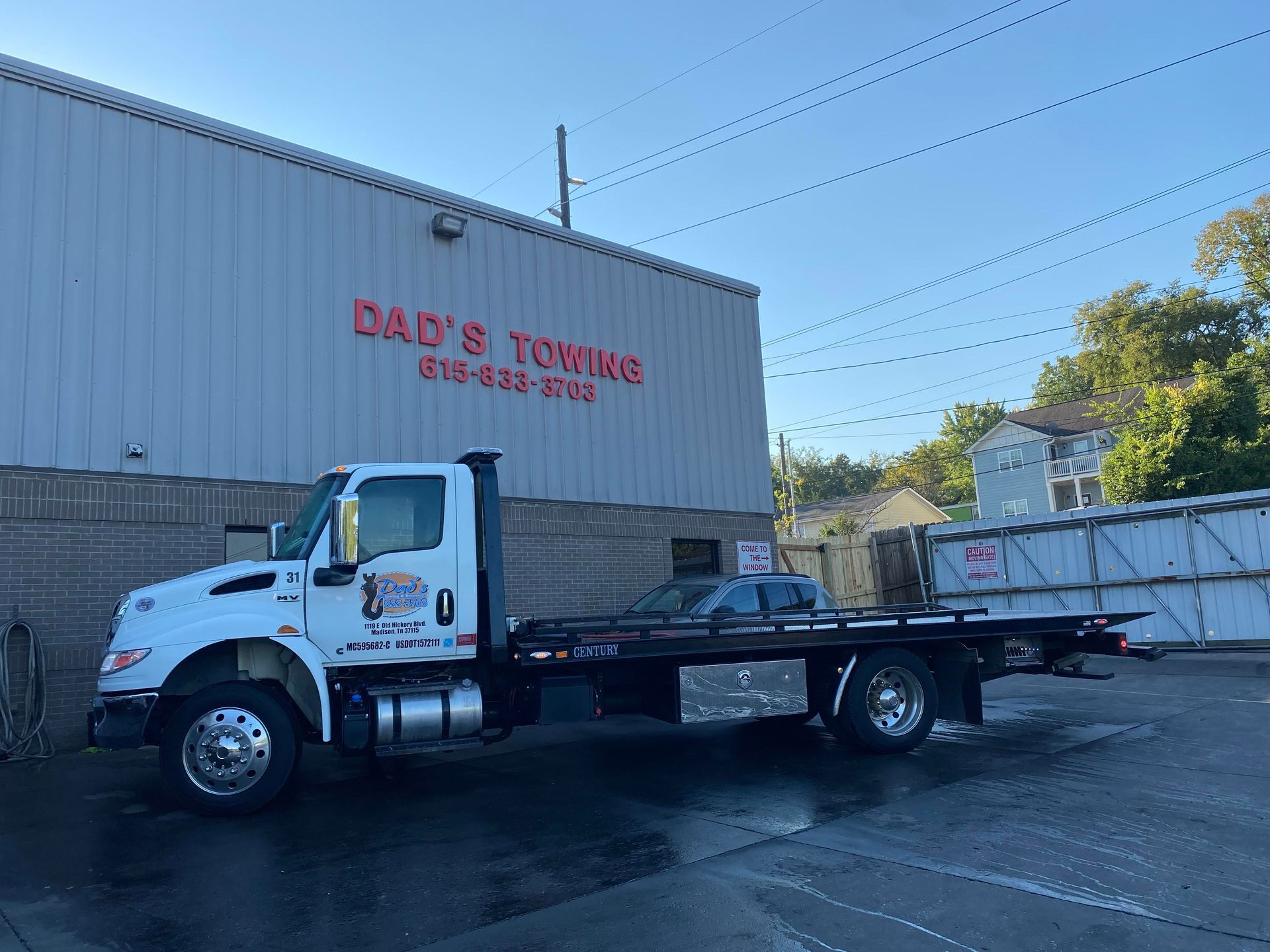 A tow truck is parked in front of a building.