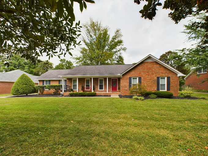 A brick house with a large lawn in front of it