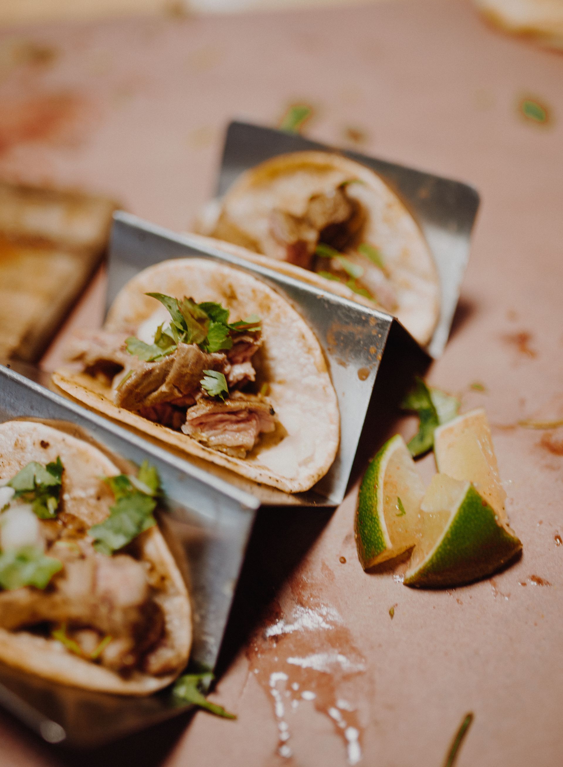 A close up of three tacos sitting on top of each other on a table.