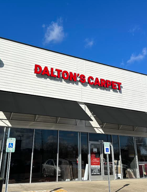 The front of a dalton 's carpet store with a blue sky in the background.