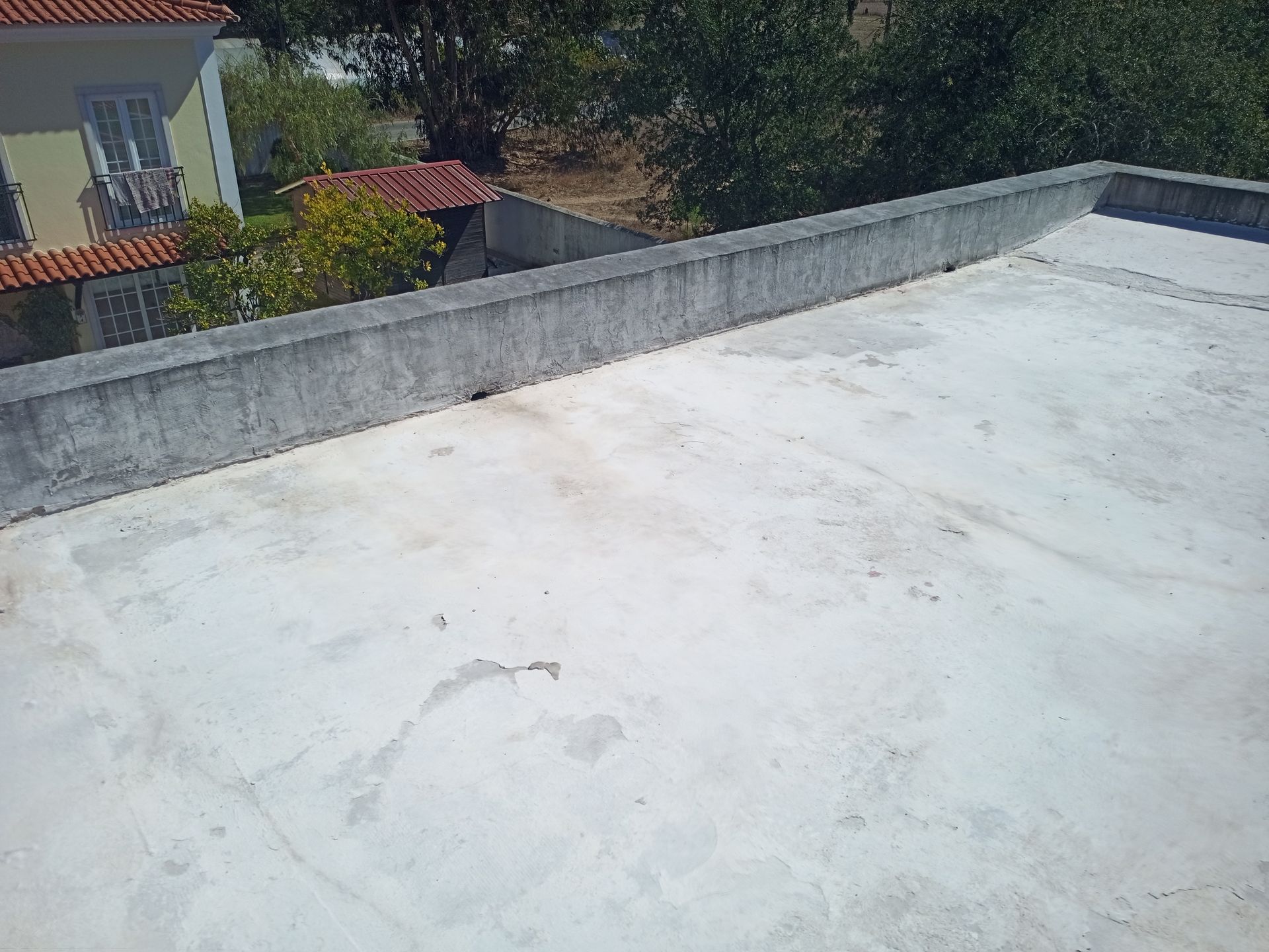 Cobertura de concreto com muro baixo, ambiente externo ensolarado.