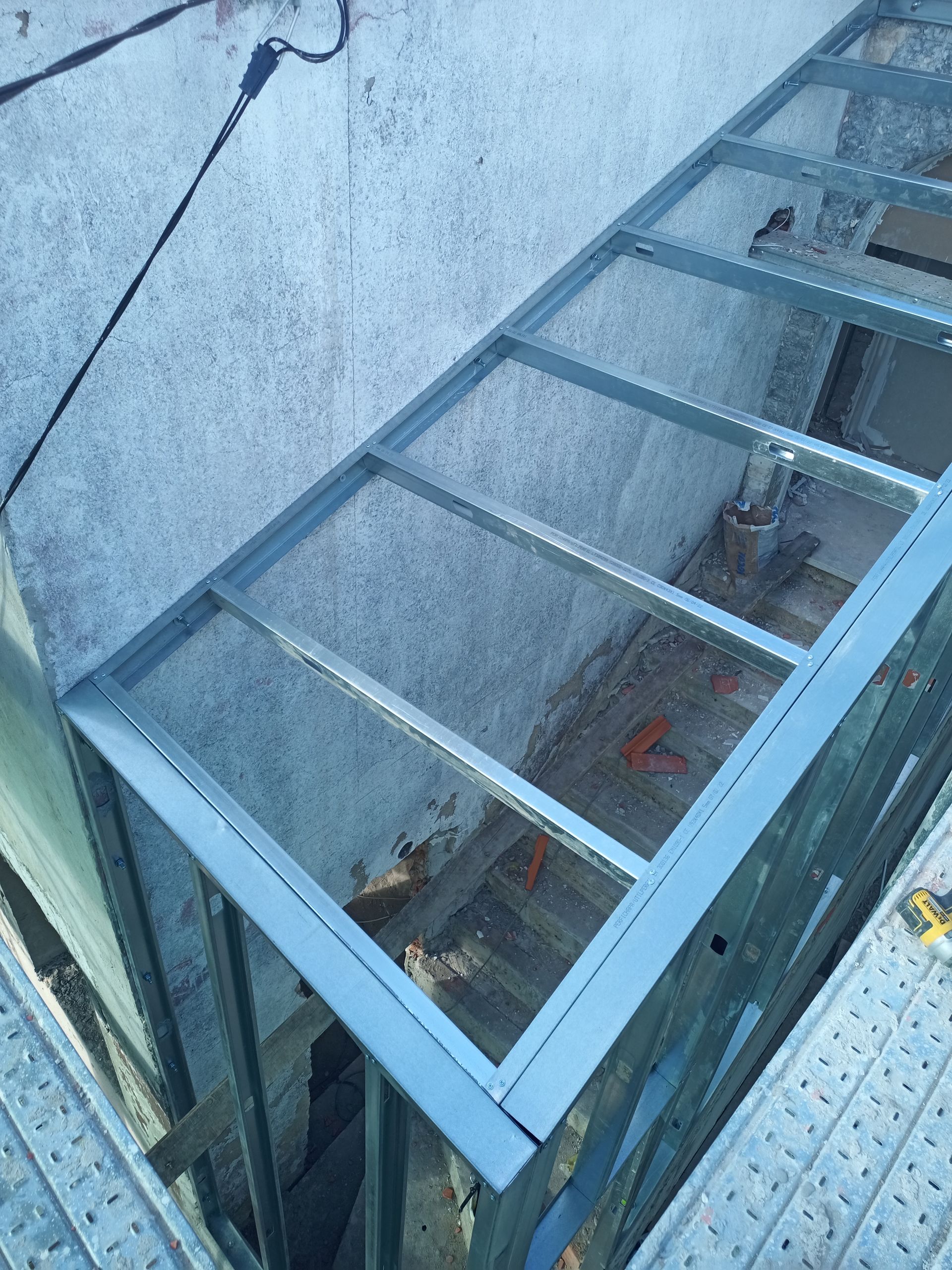 Estrutura metálica com cobertura em tela, integrada à parte externa de um edifício.