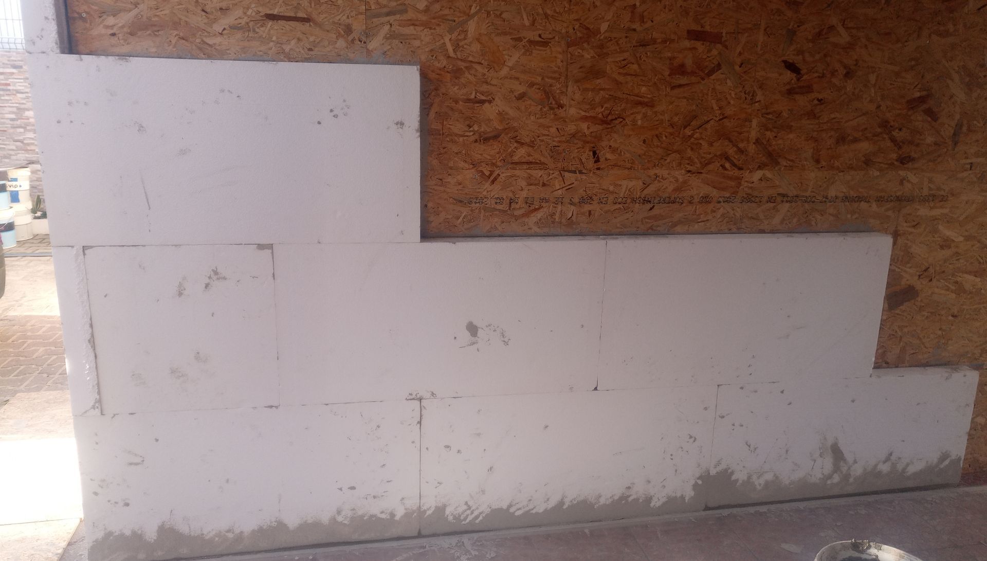 Blocos de isolamento de espuma branca parcialmente instalados sobre uma superfície de madeira.