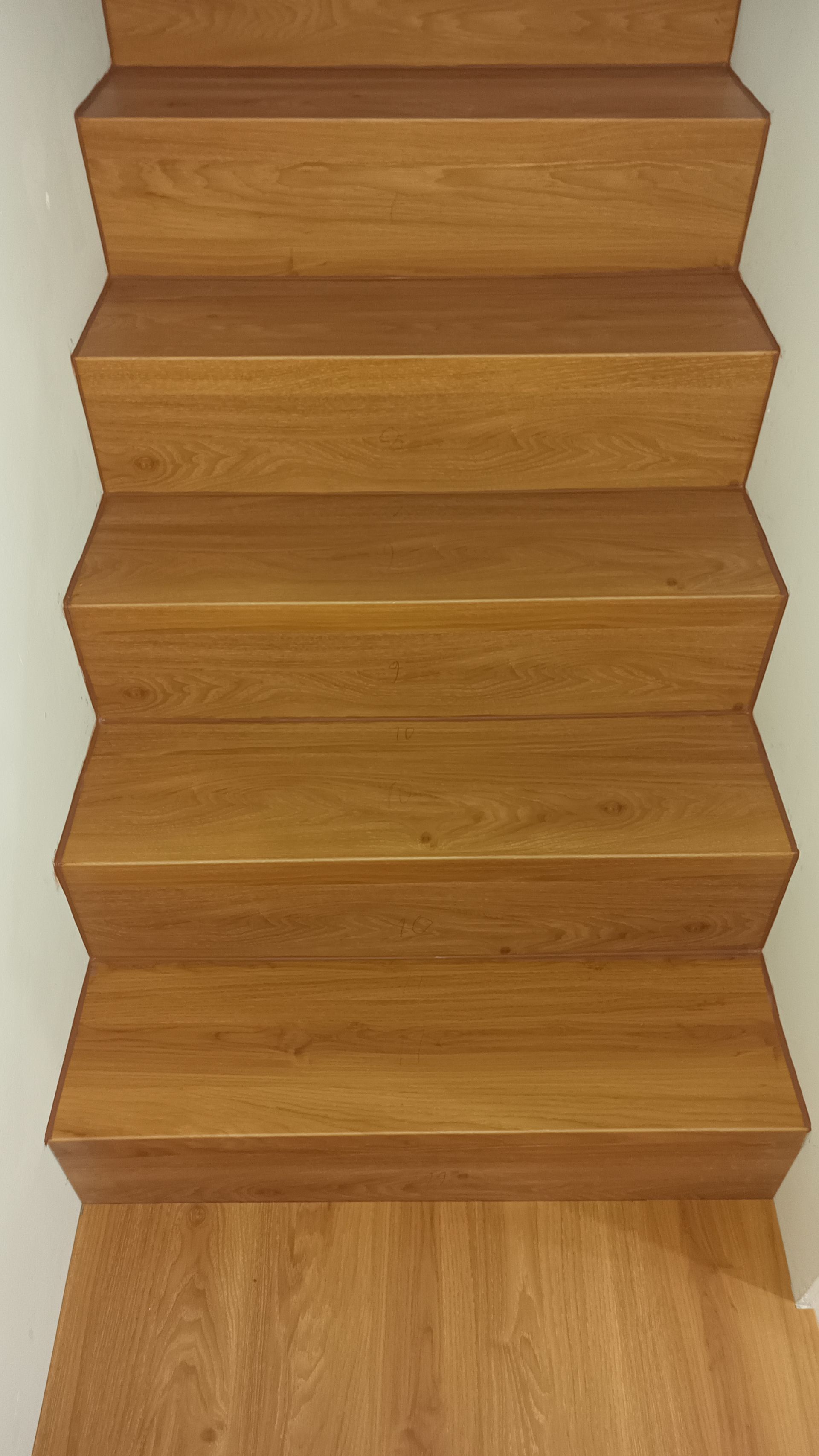 Escada de madeira que leva para cima, de cor marrom claro.