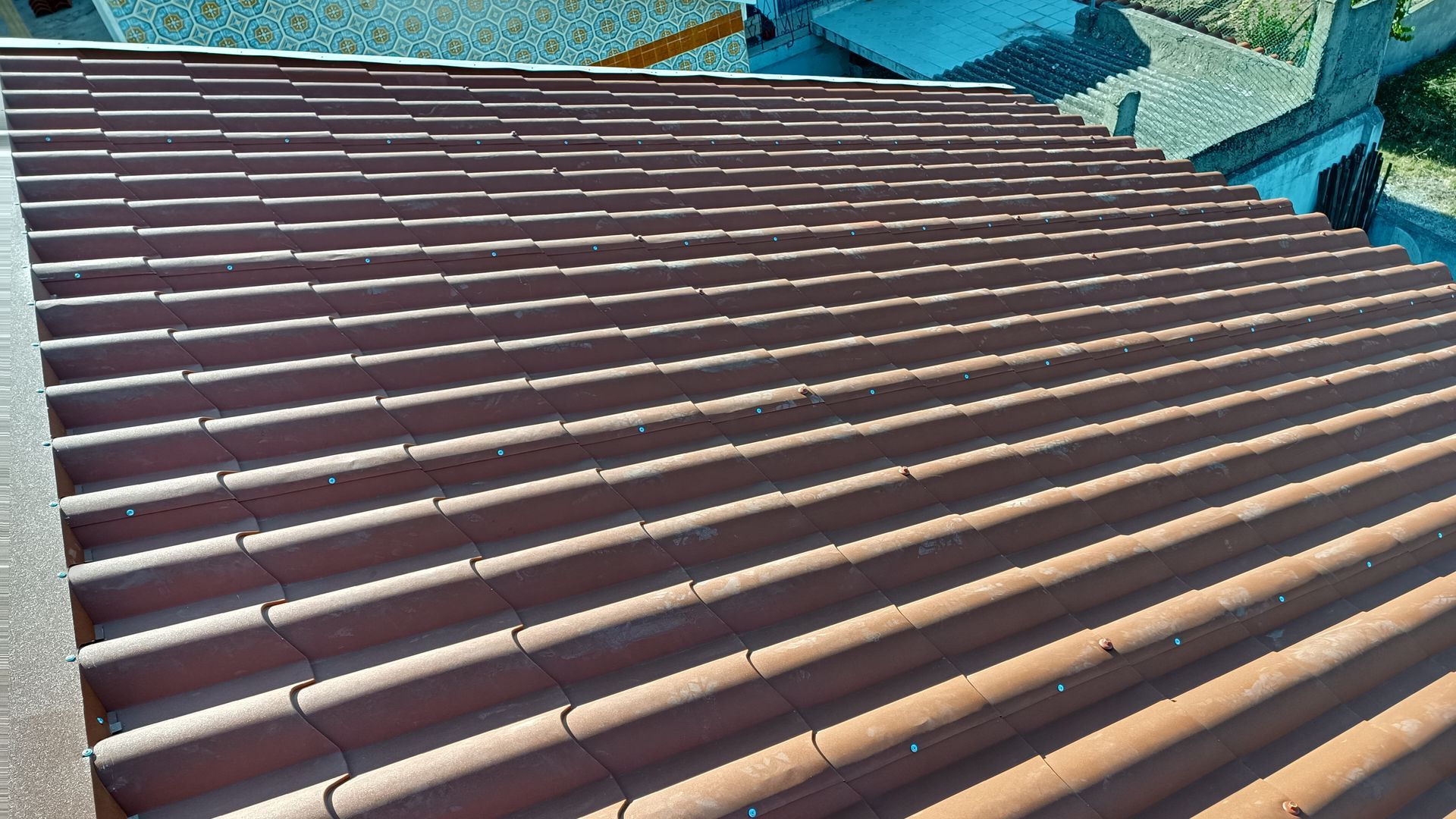 Telhado de telhas de barro marrom visto de um ponto elevado.