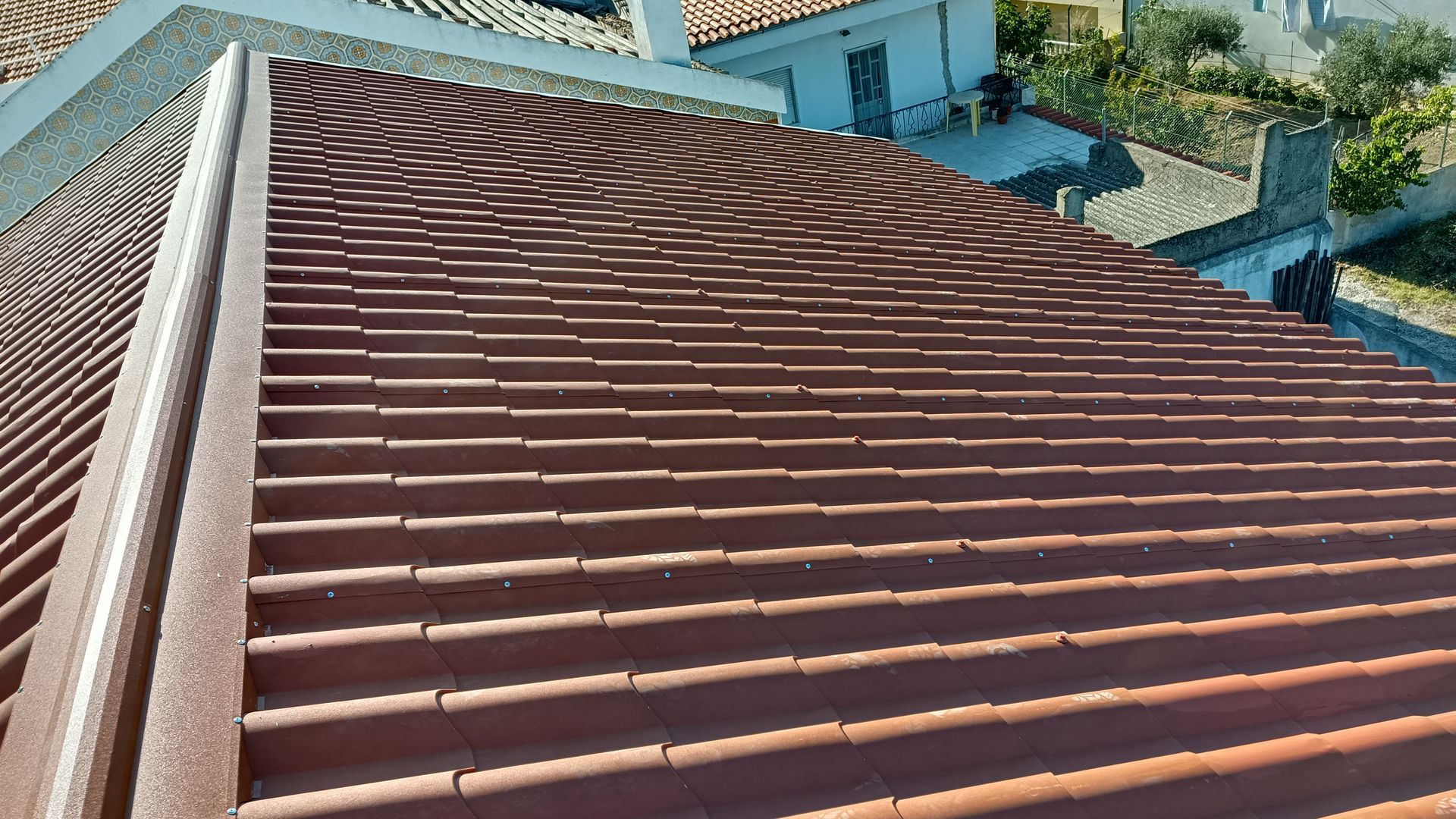 Telhado de telha marrom de um edifício, com uma calha ao longo da borda.