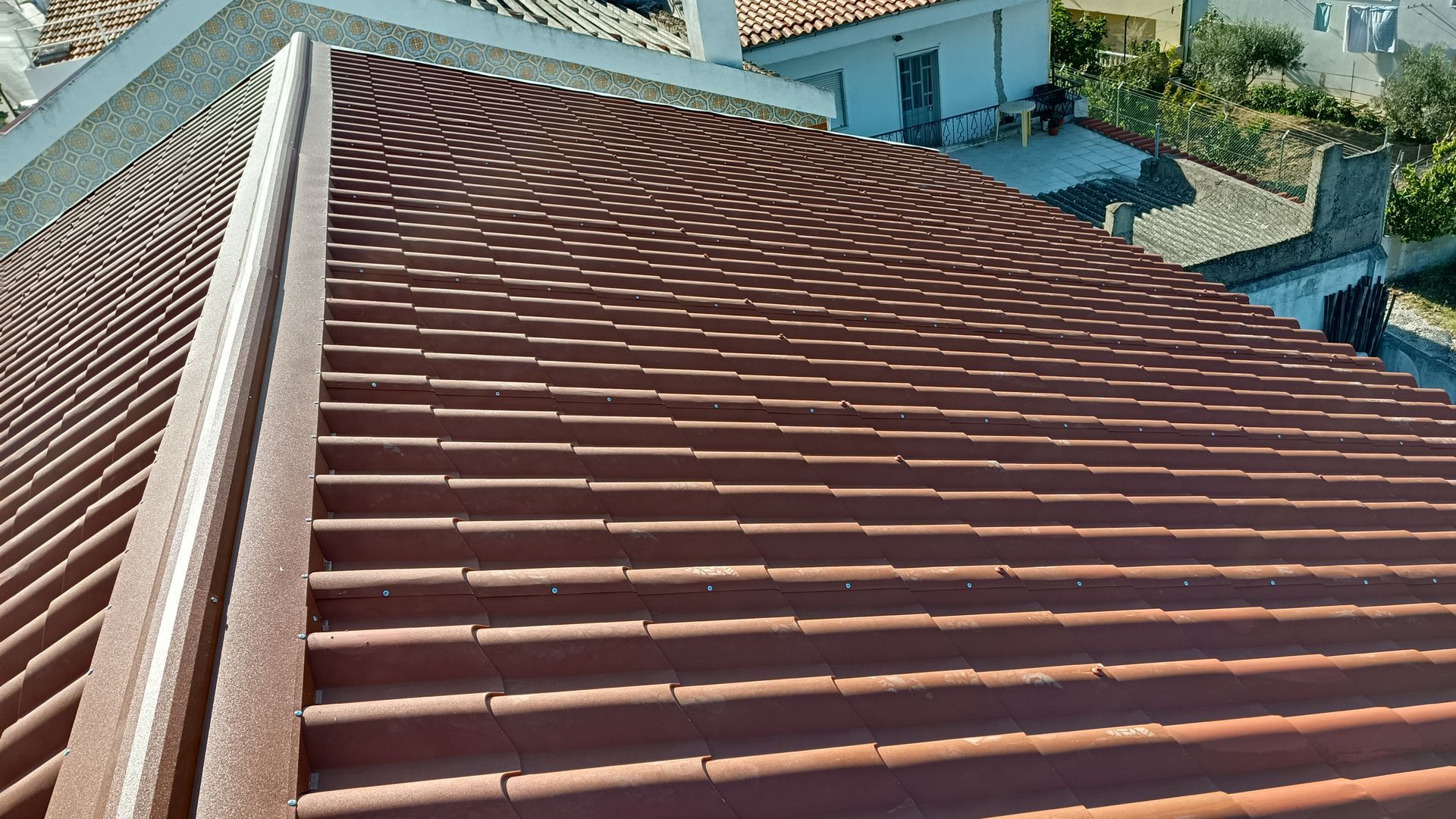 Telhado de telha de terracota marrom em um edifício, vista em ângulo.