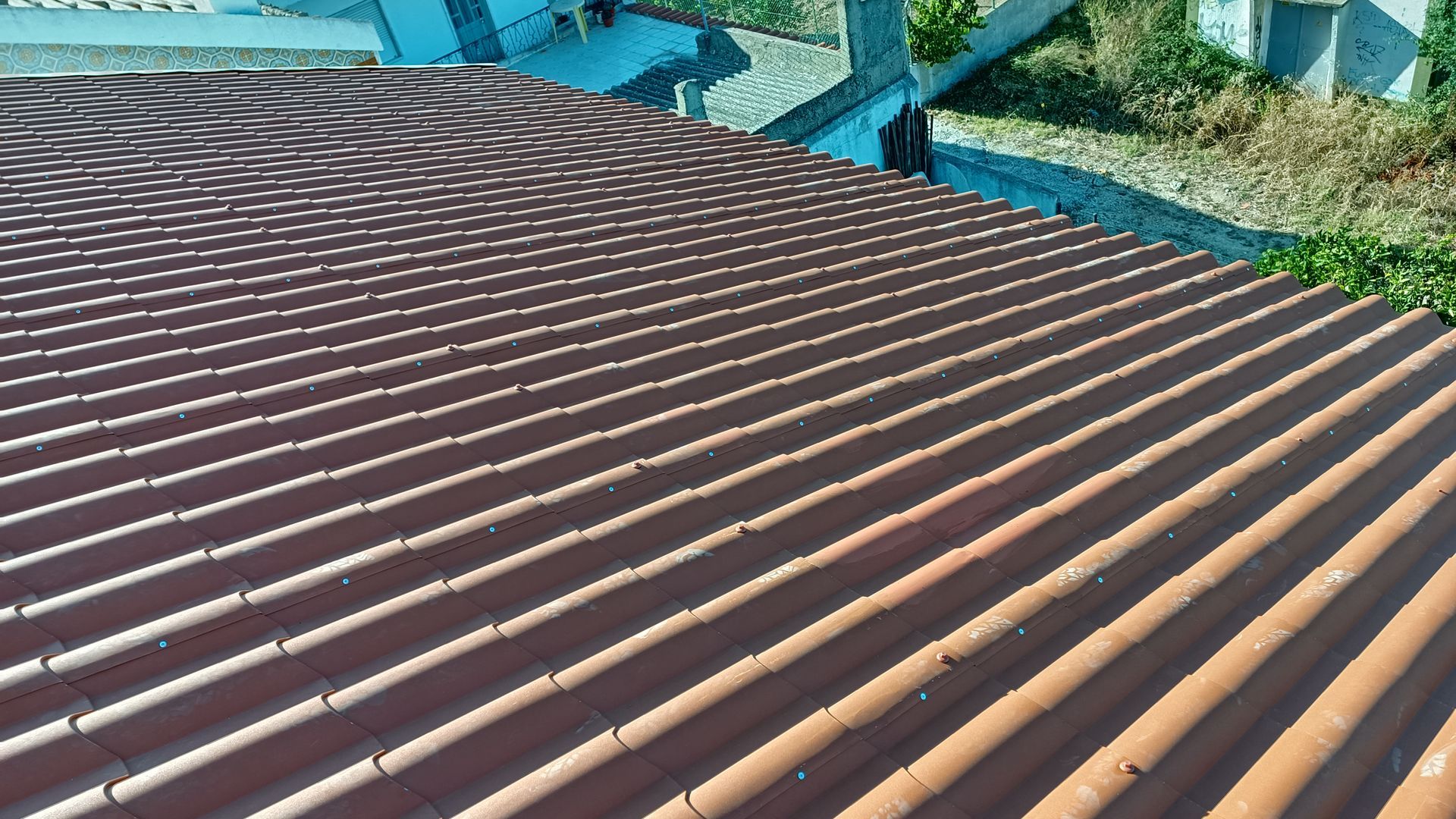 Telhas onduladas castanhas com sombras visíveis.