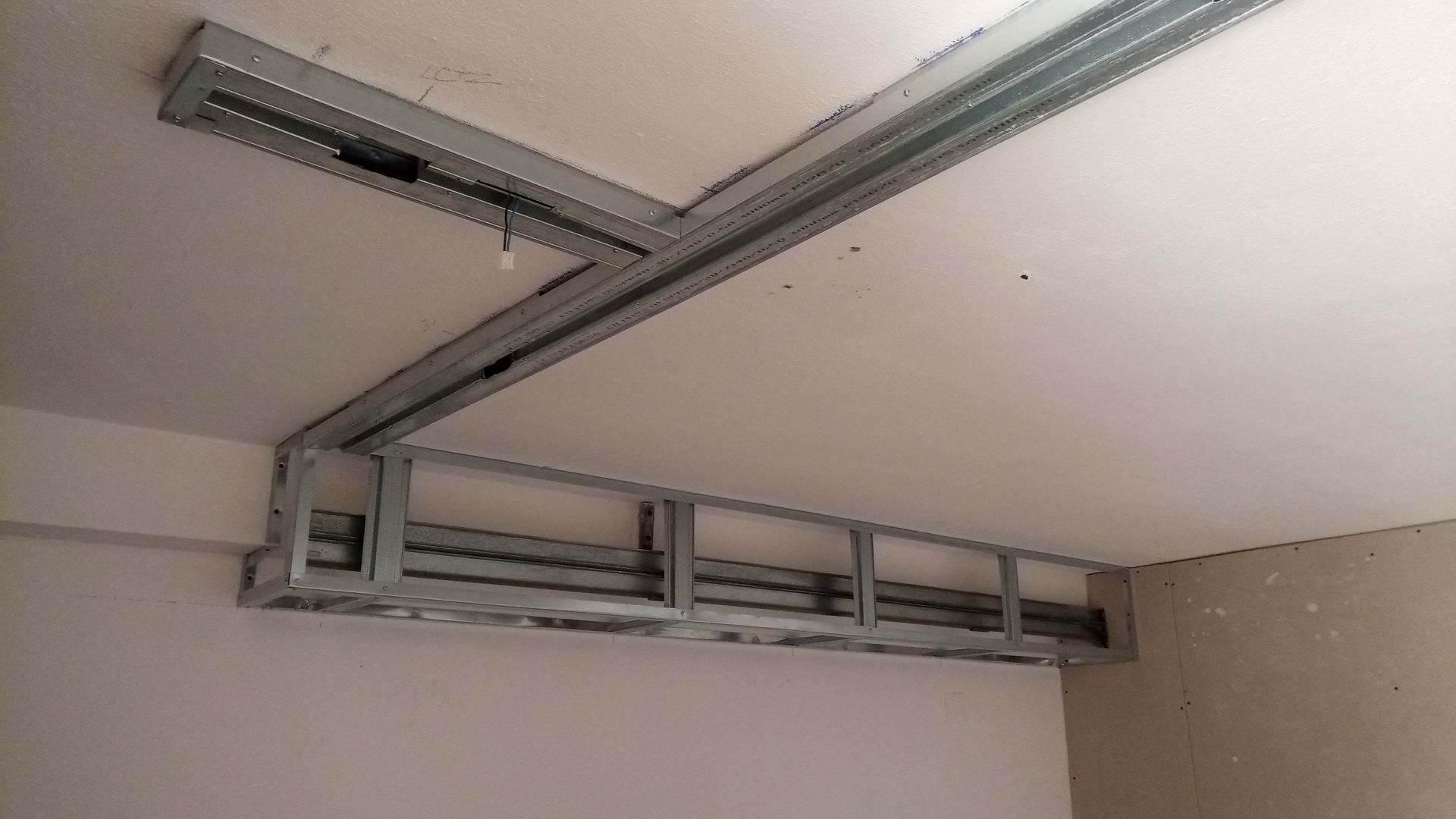 Estrutura metálica instalada no teto, formando um canto, provavelmente para drywall ou forro rebaixado.