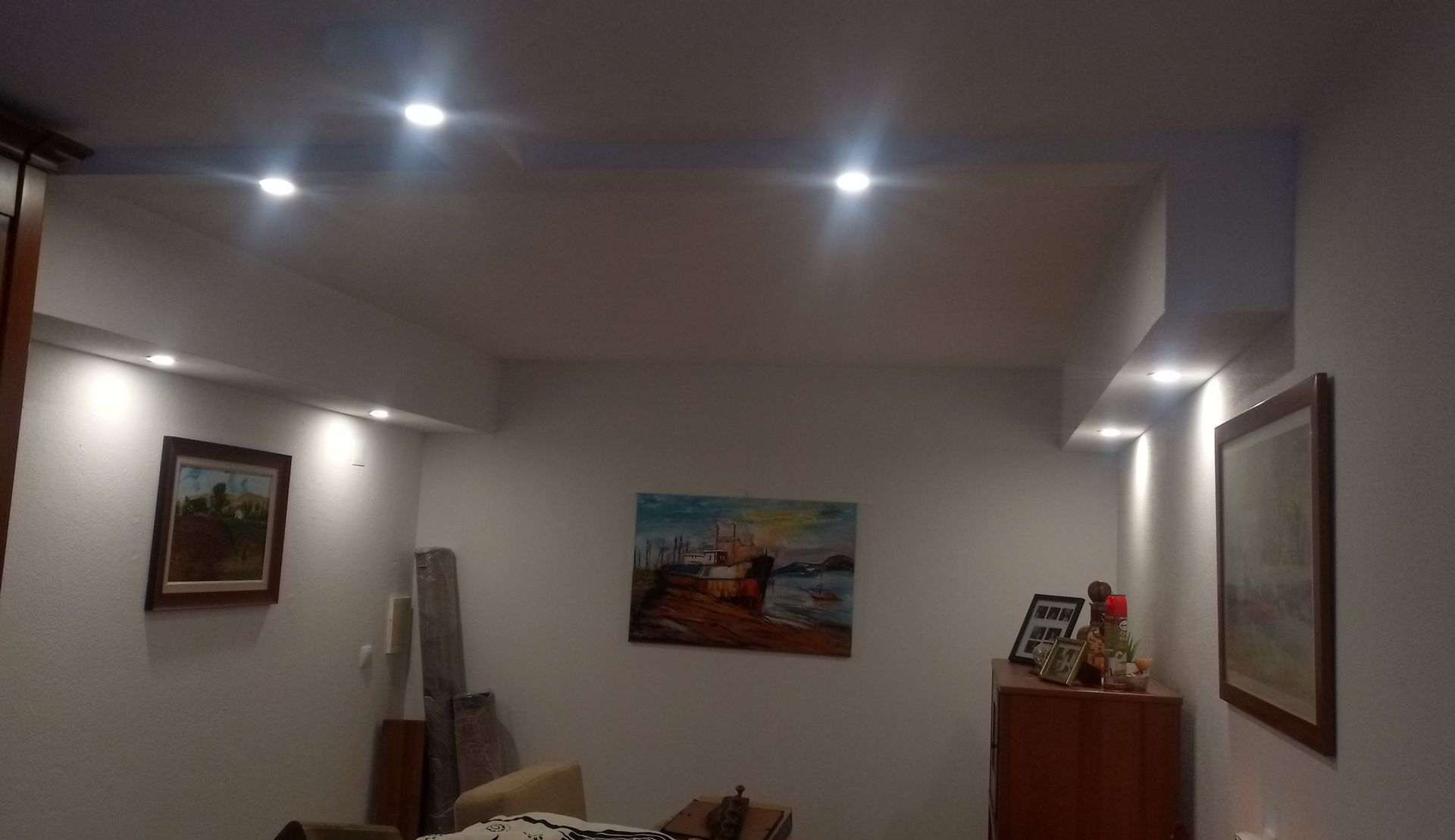 A iluminação embutida em uma sala de estar destaca obras de arte e móveis.