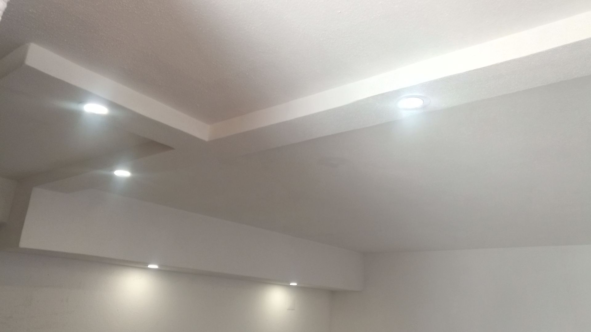 Teto branco com iluminação embutida.