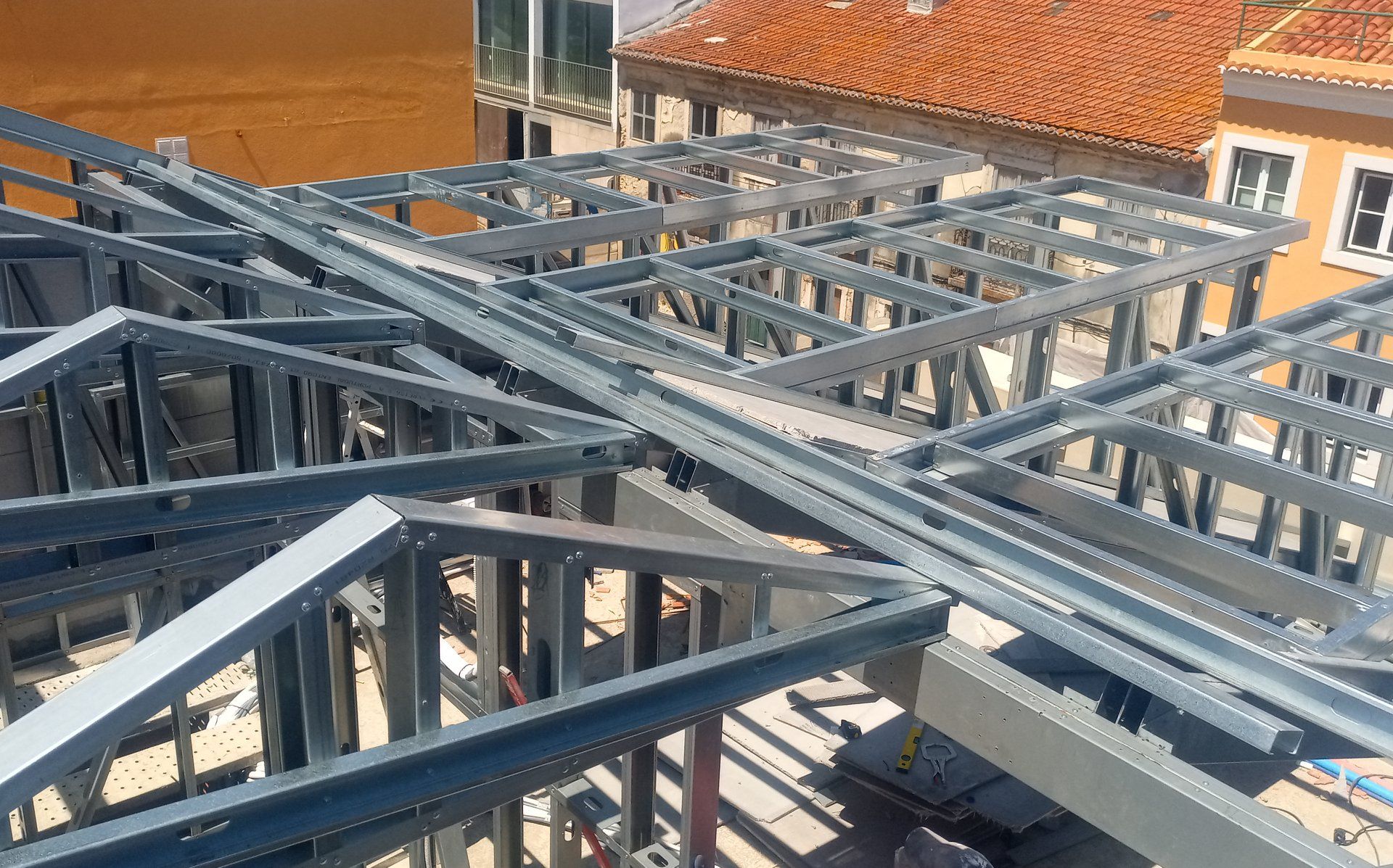 Treliças de aço para telhado sendo montadas em um edifício, canteiro de obras, vista de perto.