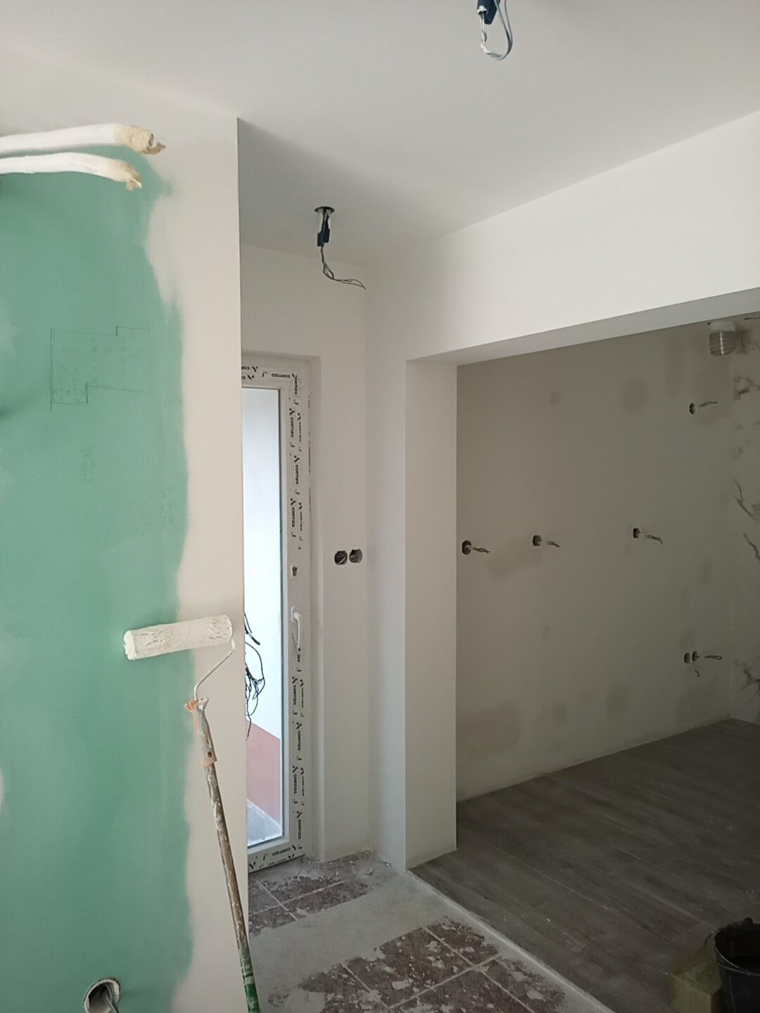 Interior em construção: drywall, porta, batente, paredes inacabadas, piso.