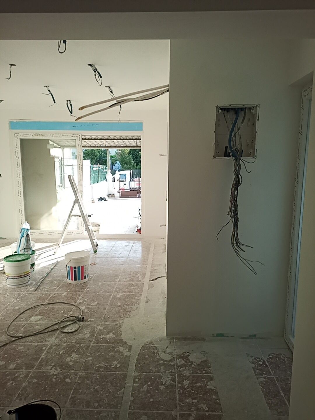 Quarto interior em reforma, com fiação exposta e paredes parcialmente pintadas.