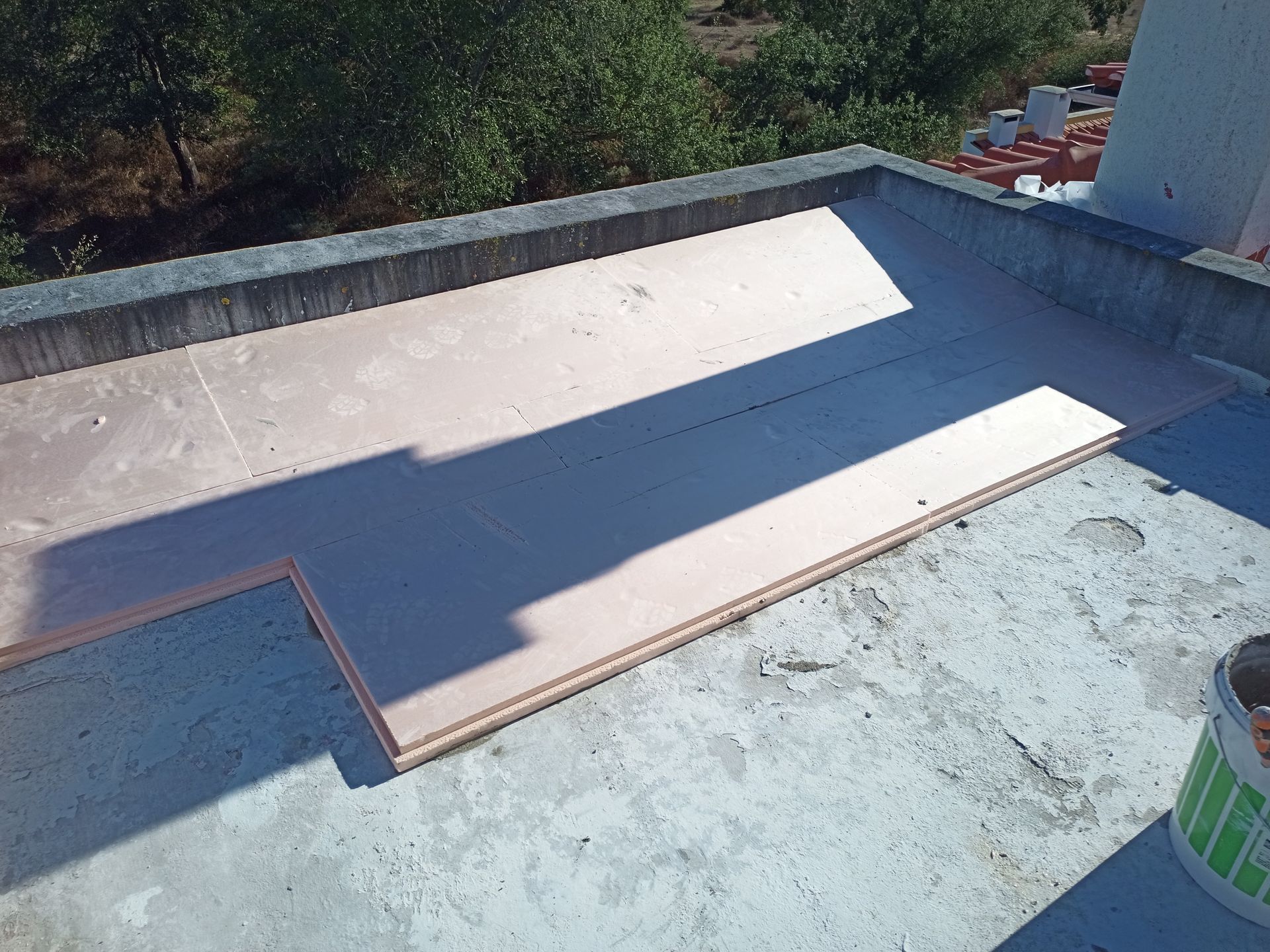 Telhado plano de concreto com placas de isolamento rosa instaladas.