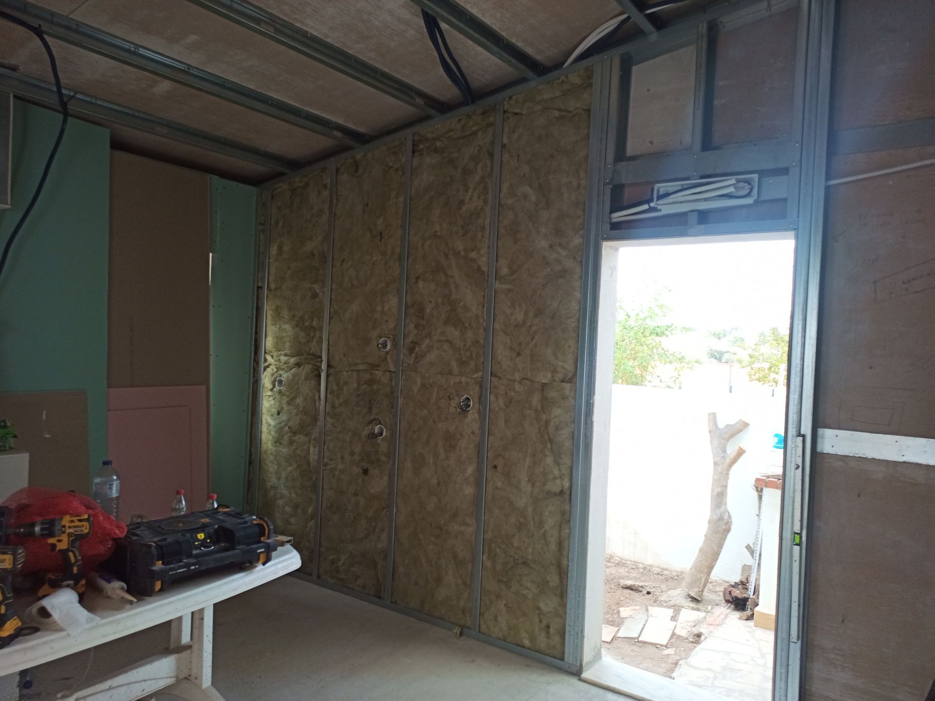 Construção interior: estrutura metálica com isolamento; batente da porta aberto para o exterior.