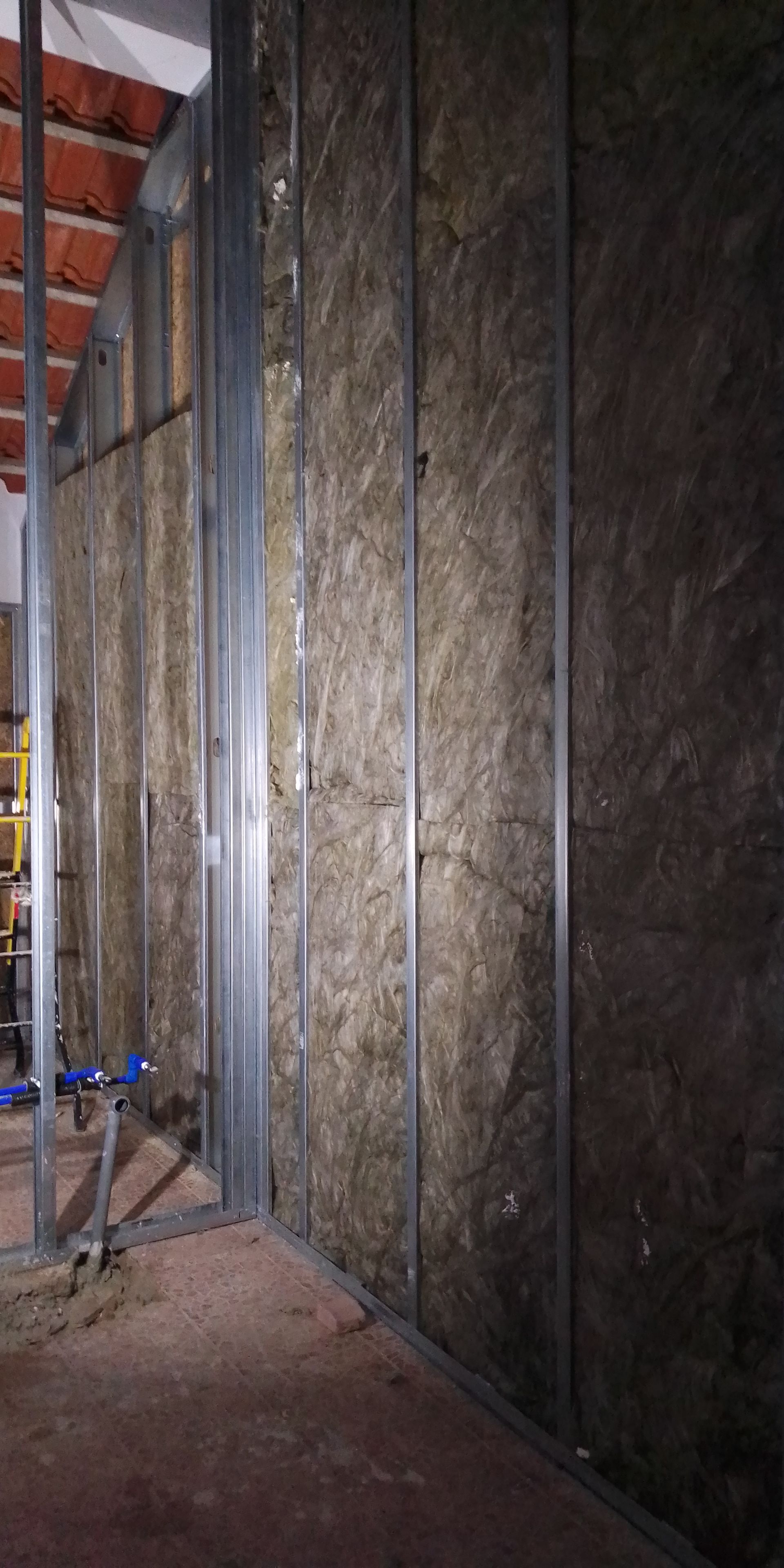 Construção de uma parede interna, perfis metálicos, isolamento entre eles. Interior do edifício.