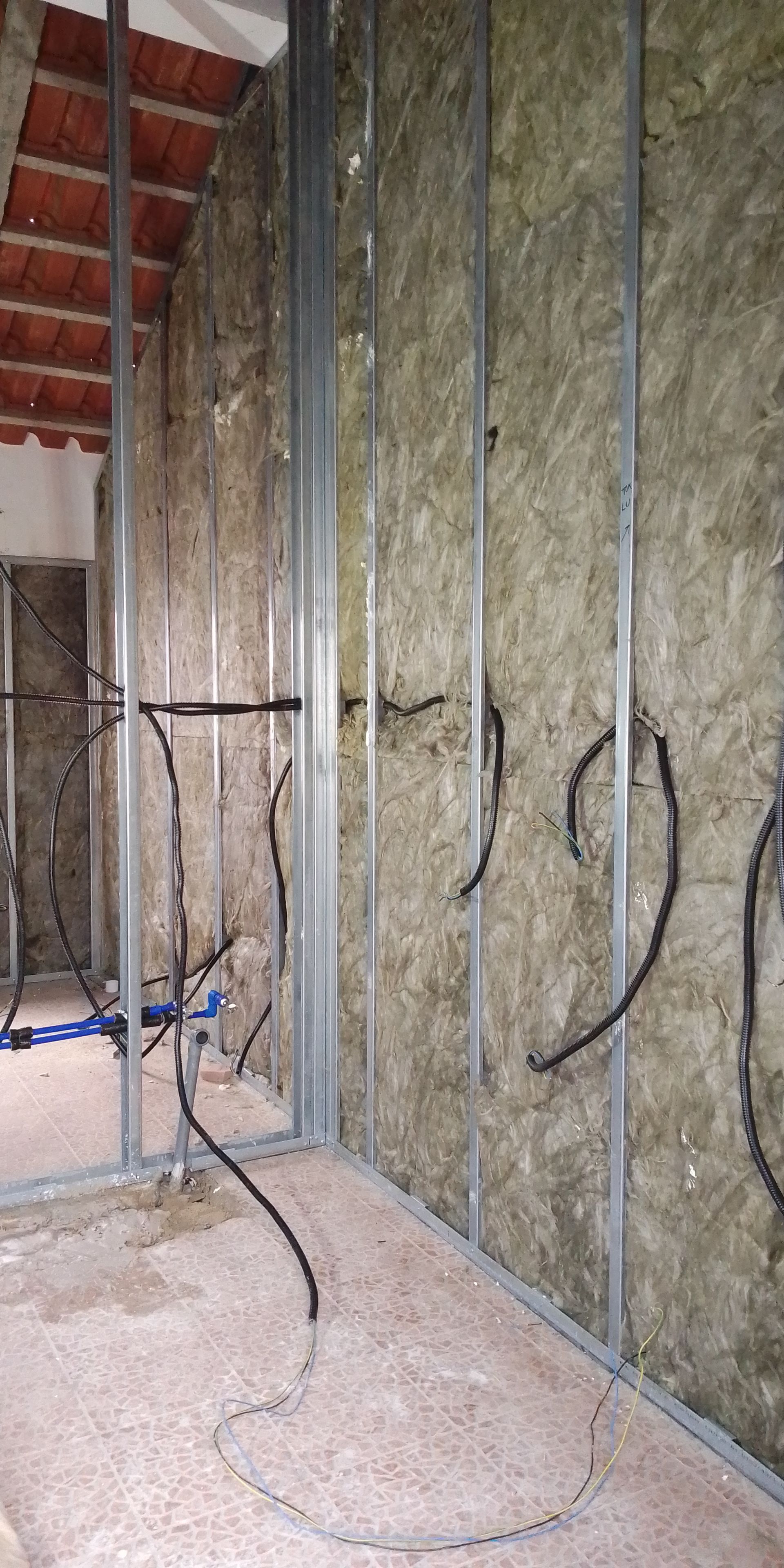 Construção interna em andamento. Estrutura metálica e isolamento instalados. Fiação elétrica visível.